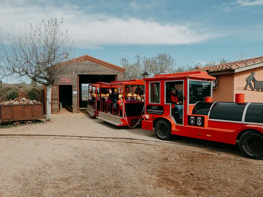 Tren minero rojo con visitantes en el Parc Miner del Maestrat durante la excursión desde Valencia