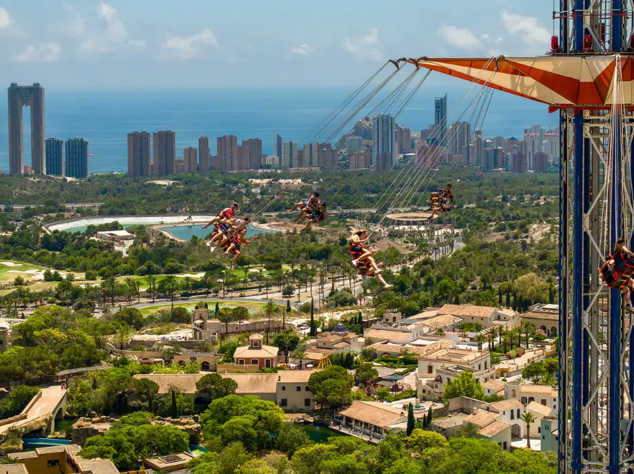 Vista panorámica de Terra Mítica en Benidorm con atracciones y skyline de la ciudad al fondo.