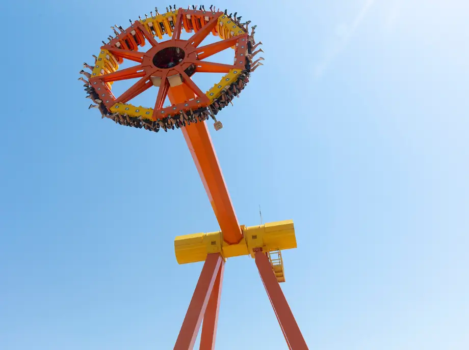 Atracción giratoria de Terra Mítica en Benidorm elevándose sobre un cielo azul.