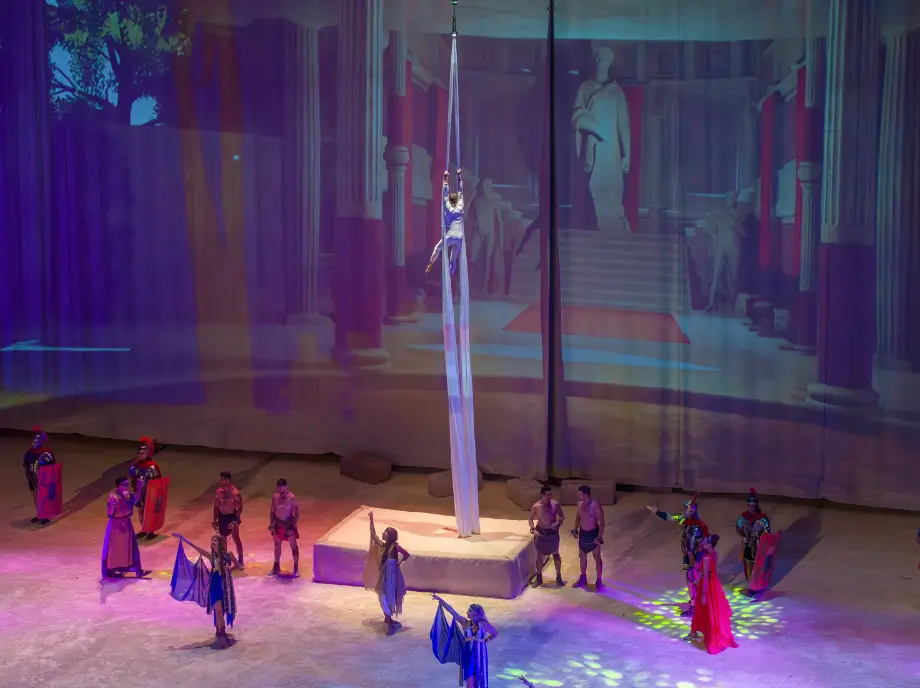 Show nocturno en Terra Mítica Benidorm con acróbatas, luces y escenario iluminado.