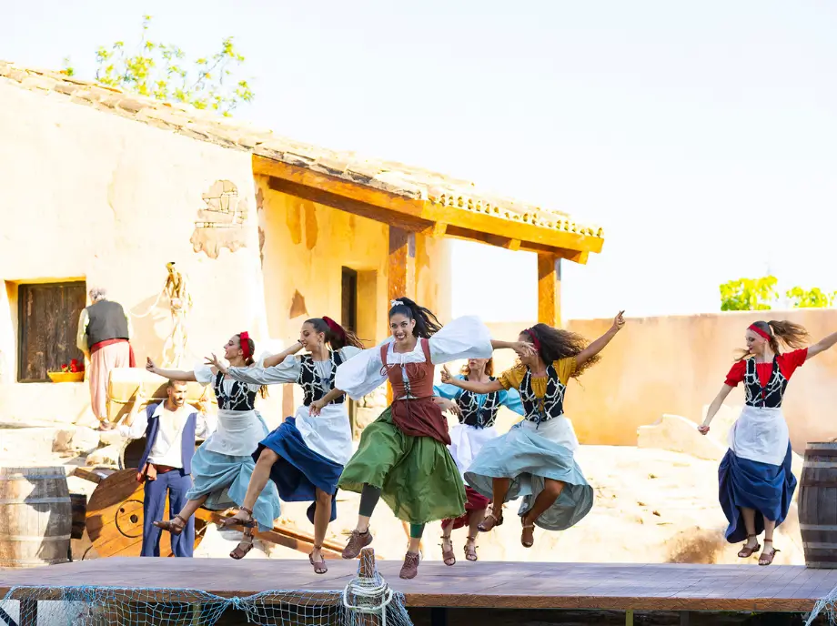 Espectáculo de baile en Terra Mítica Benidorm con artistas actuando sobre un escenario temático.
