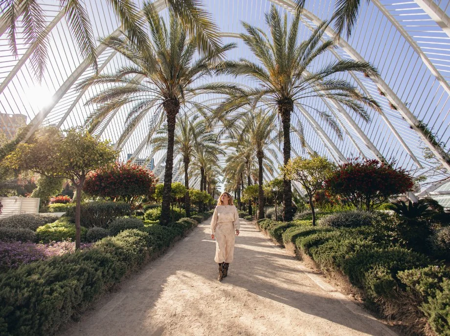 Donna che passeggia tra le palme nel giardino de L'Umbracle, Città delle Arti e delle Scienze di Valencia.