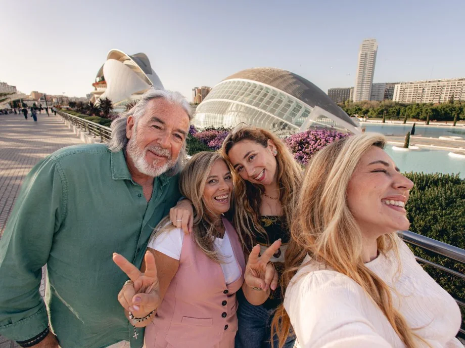 Famiglia che si scatta un selfie con l'Hemisfèric e il Palau de les Arts sullo sfondo a Valencia.