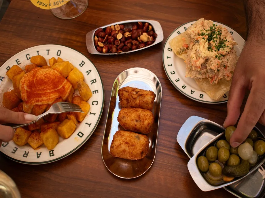 Selección de tapas típicas españolas con bravas, croquetas, ensaladilla, aceitunas y frutos secos