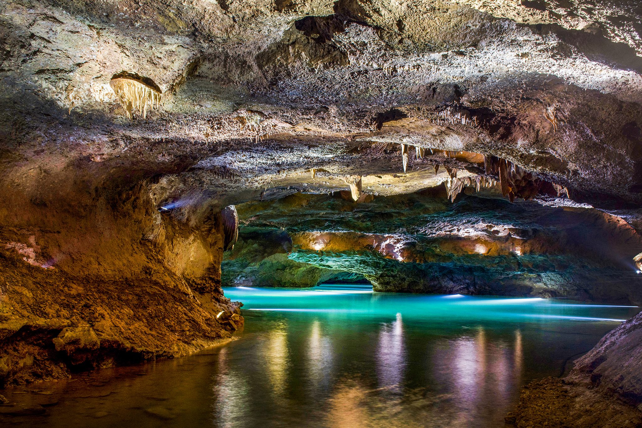 Lago subterráneo de aguas turquesas y estalactitas en las Cuevas de San José
