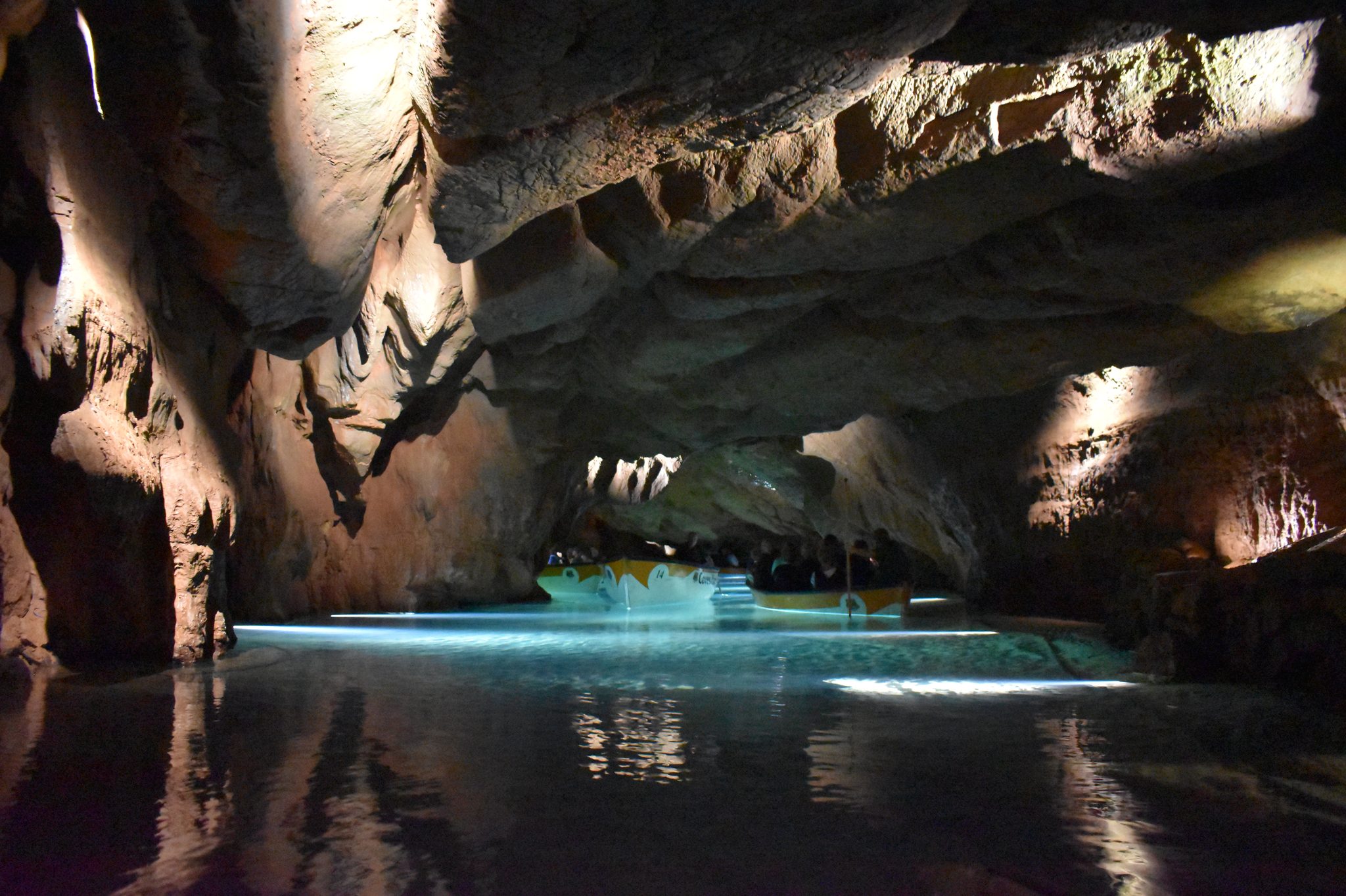 Barca navegando por el río subterráneo iluminado de las Cuevas de San José