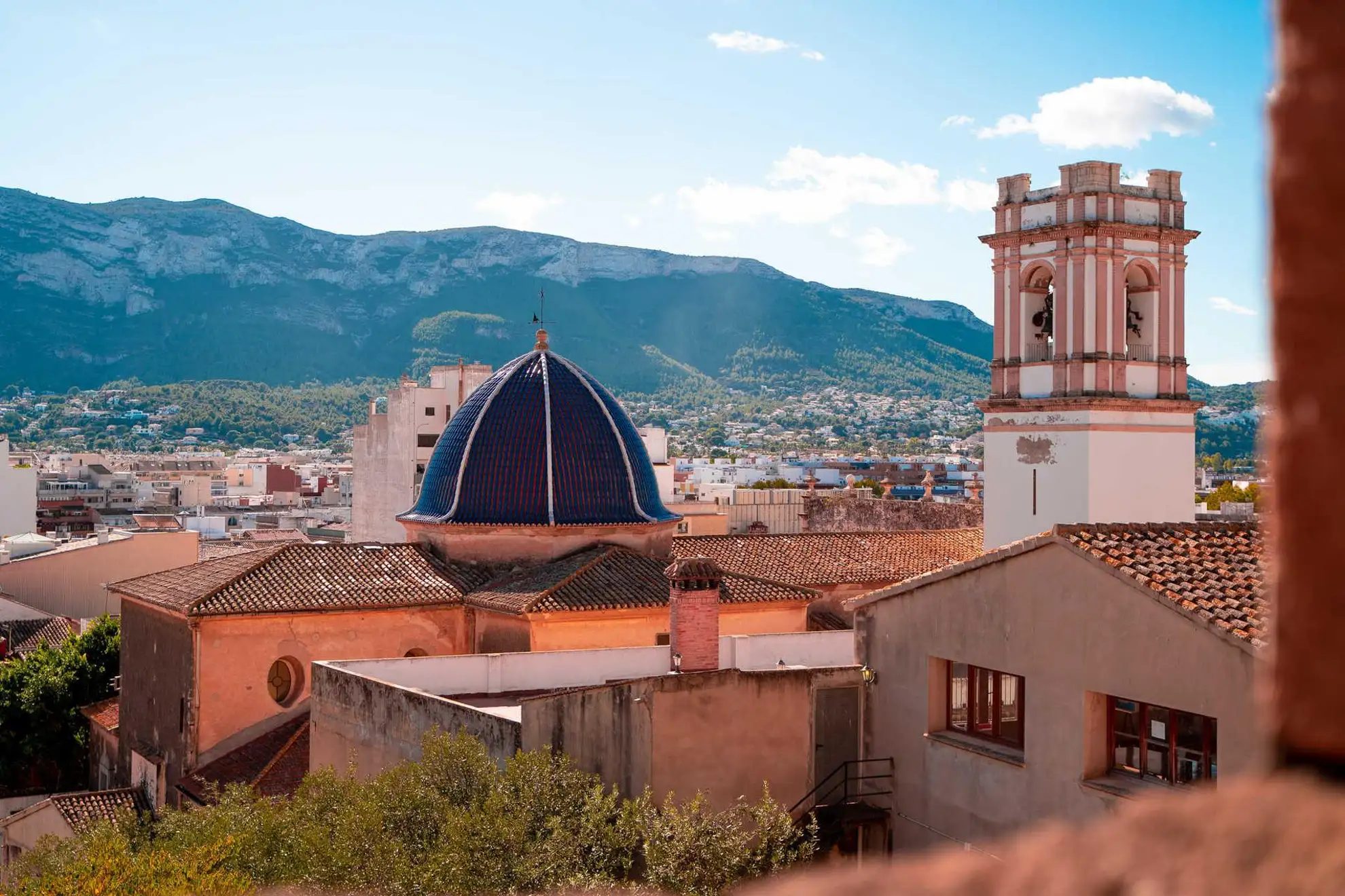 Cúpula azul y campanario de Dénia con el macizo del Montgó al fondo