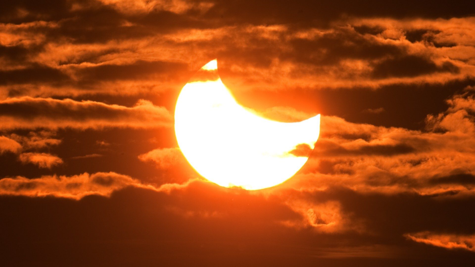 Eclissi solare parziale tra le nuvole nel cielo di Requena