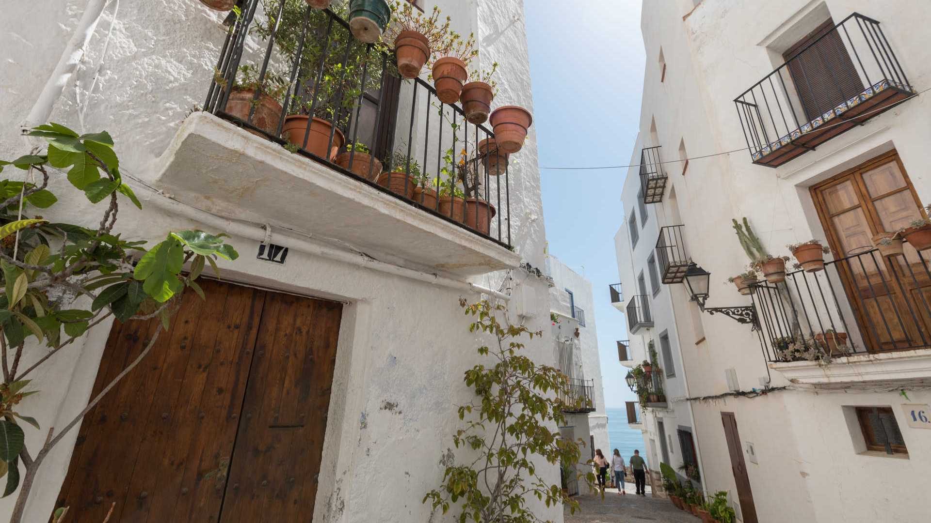 Calles blancas y balcones con flores del casco histórico de Peñíscola