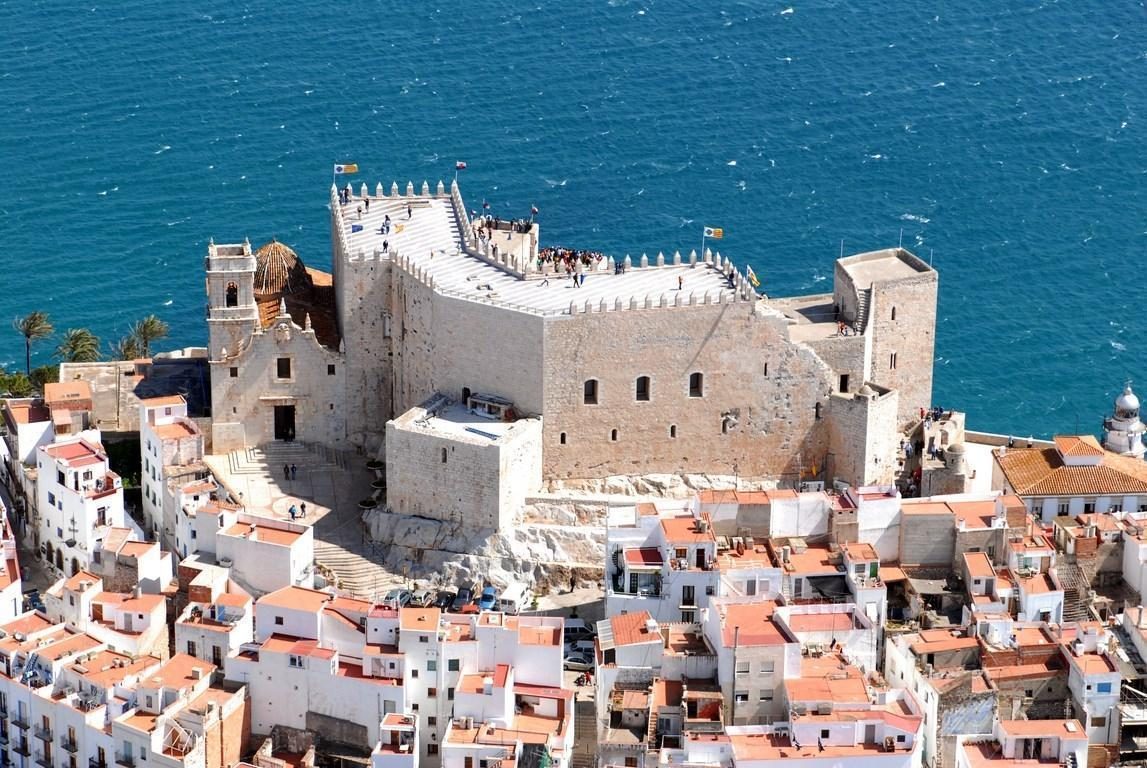 El Castillo de Peñíscola sobre el peñón, con los tejados del casco antiguo y el Mediterráneo
