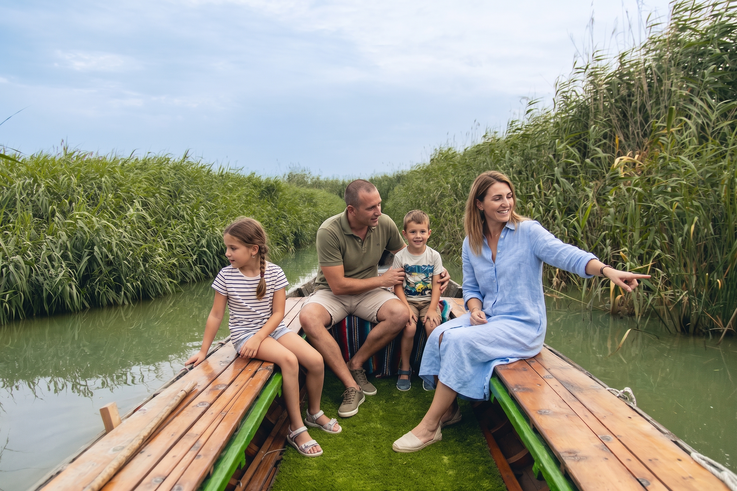 Familia con niños disfrutando de un paseo por la Albufera de Valencia, rodeados de naturaleza y paisajes tradicionales valencianos.
