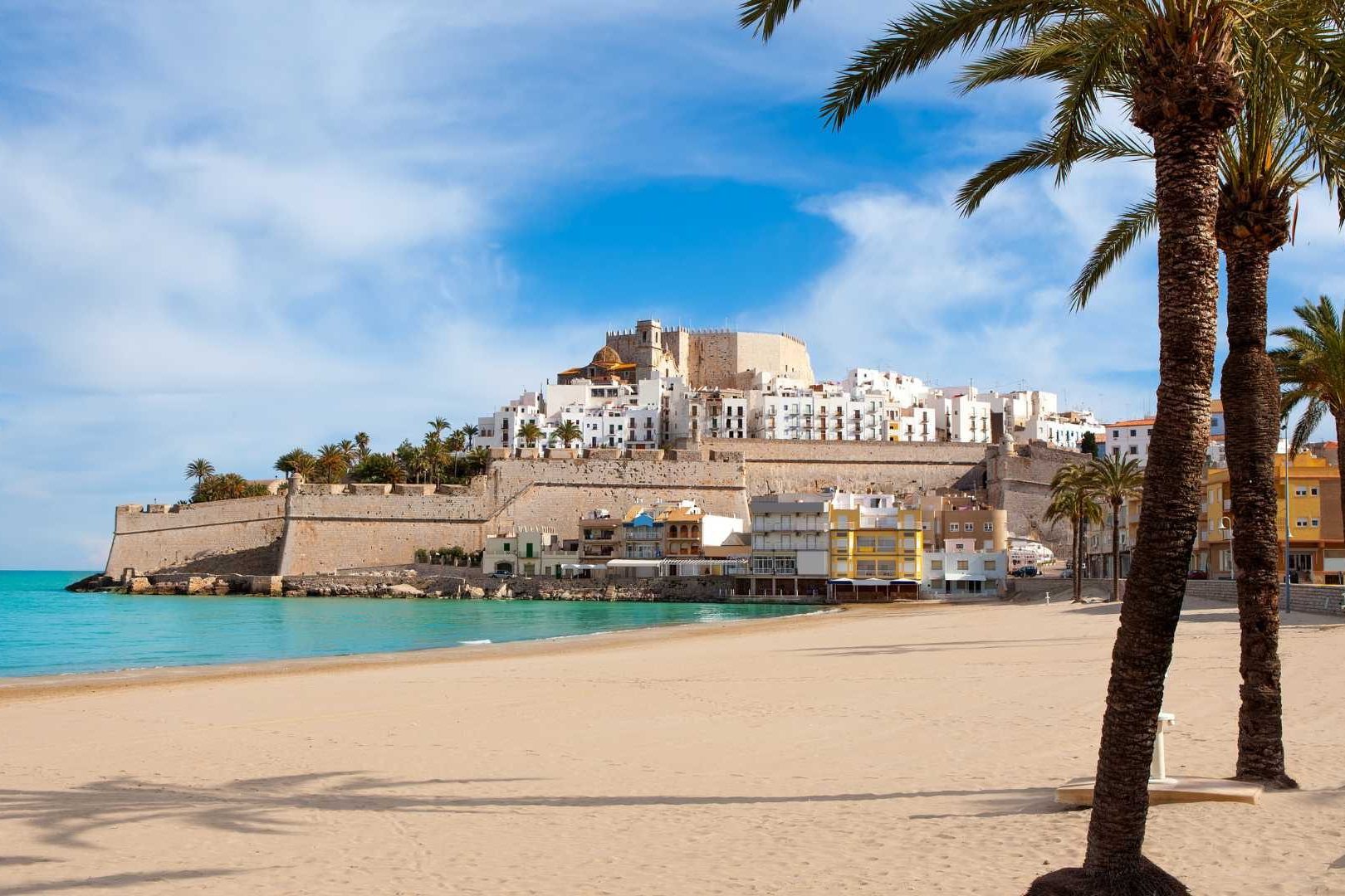 Peñíscola beach with palm trees and the castle in the background