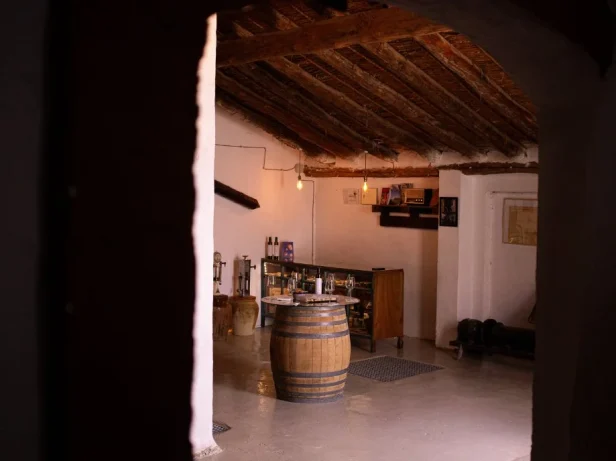 Interior de bodega tradicional en Requena con barrica de vino y copas preparadas para una cata.