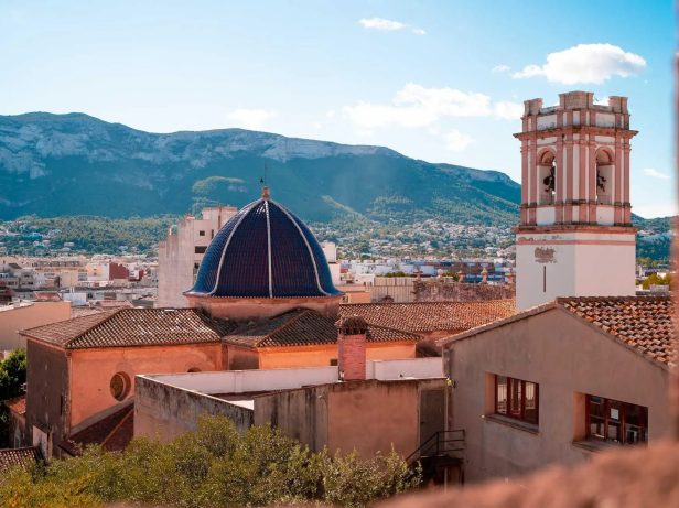 Cúpula azul y campanario de Dénia con el macizo del Montgó al fondo